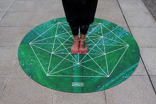 united kingdom person standing on round green Form mat darts